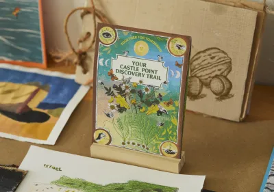 A photograph of 'Your Castle Point Discovery Trail' with artworks behind it